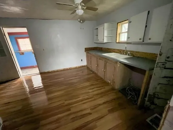 a view of a kitchen with a sink and wooden floor