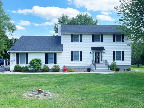 a front view of a house with a yard and trees