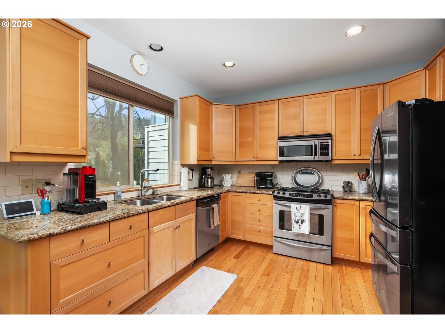 5047 Southwest View Point Terrace, Unit C Portland, OR 97239 - Photo 11 of 38 a kitchen with stainless steel appliances granite countertop a stove a sink dishwasher and a refrigerator
