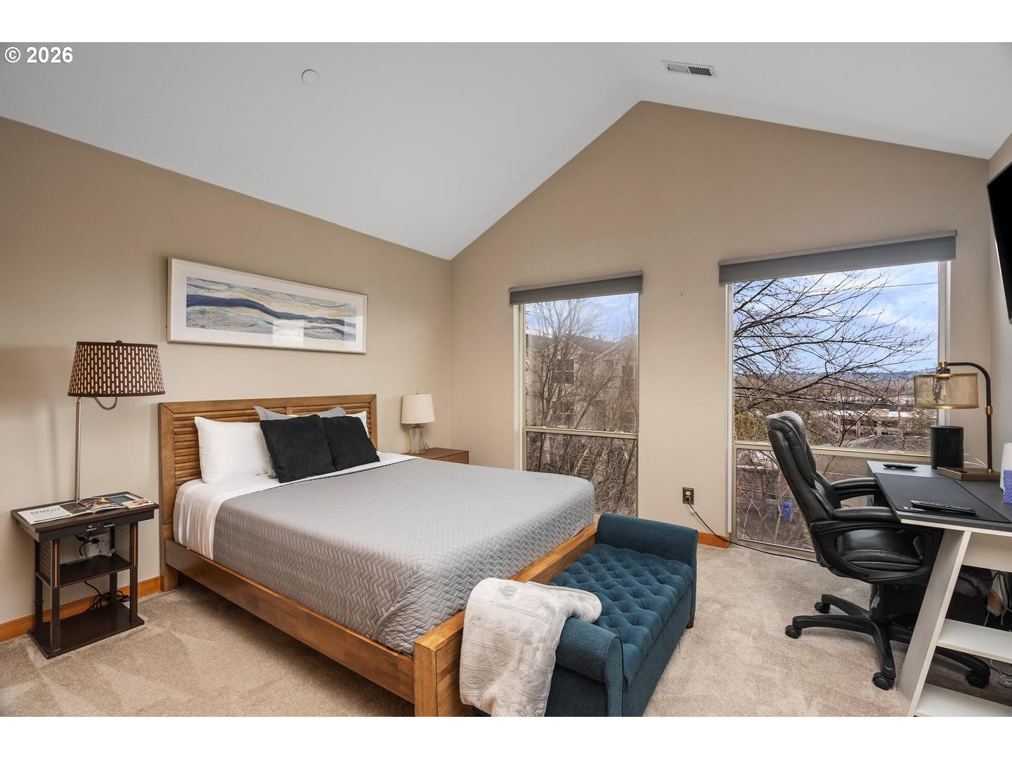 5047 Southwest View Point Terrace, Unit C Portland, OR 97239 - Photo 25 of 38 a bedroom with a bed a desk and chair with large windows