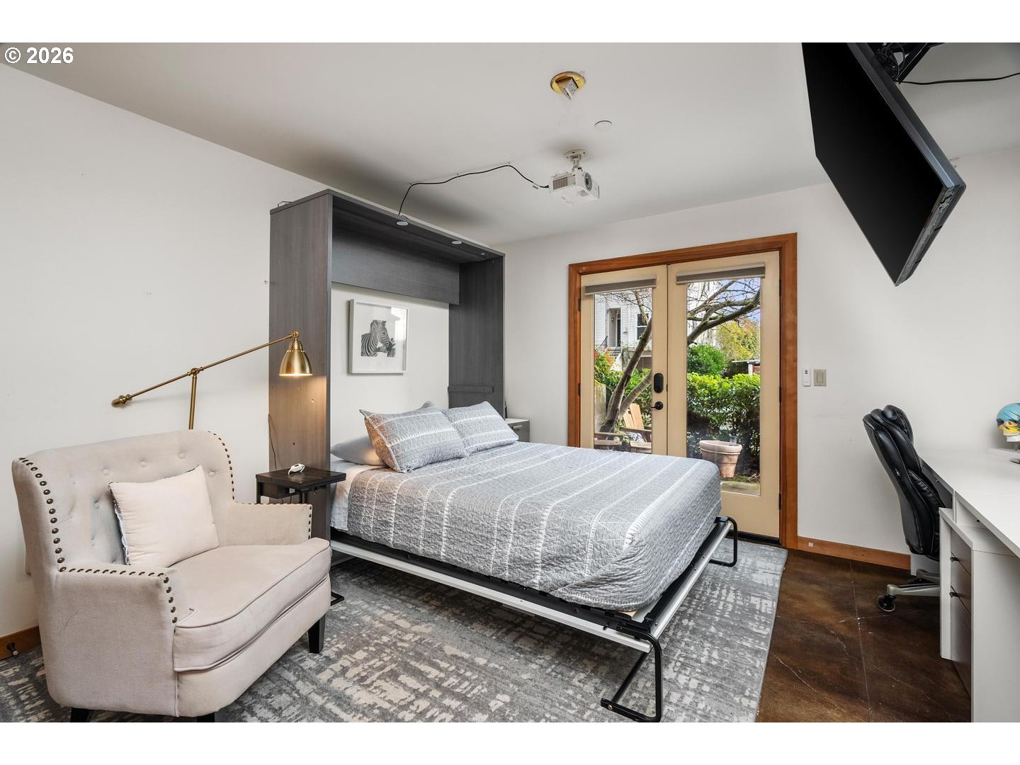 5047 Southwest View Point Terrace, Unit C Portland, OR 97239 - Photo 30 of 38 a bedroom with a bed a couch and a flat tv screen on dresser