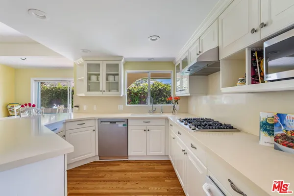 a kitchen with granite countertop a refrigerator and a stove top oven