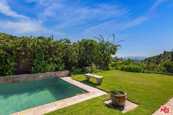 a view of a house with swimming pool and a yard