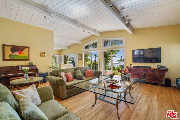 a living room with furniture a rug and a wall painting