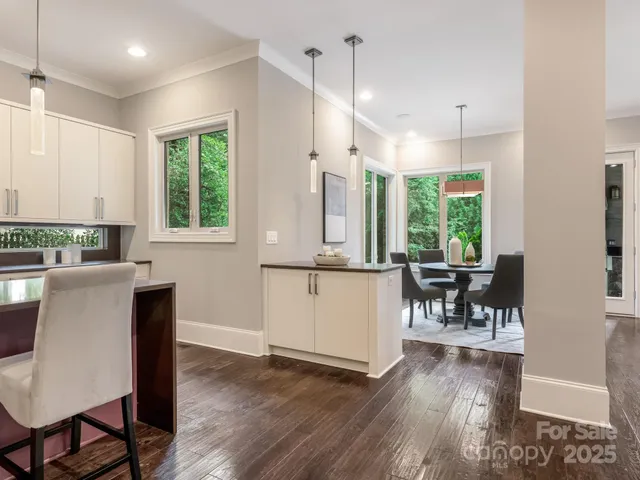 a kitchen with kitchen island granite countertop wooden floors and a large window