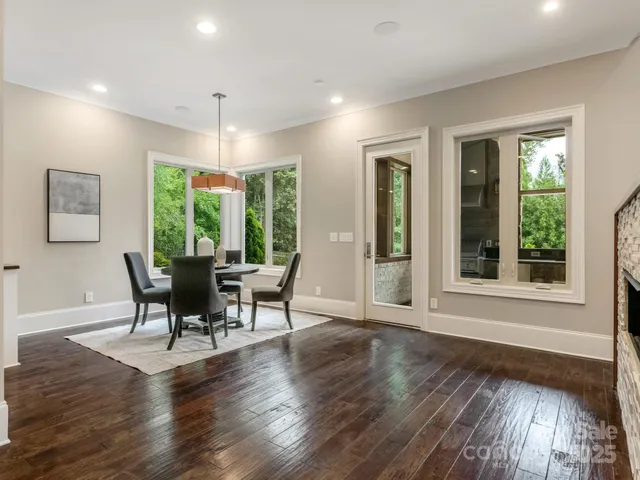 a dining room with wooden floor a chandelier a glass table and chairs