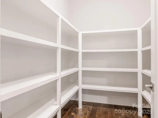 a view of walk in closet with empty racks