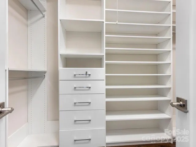 a view of walk in closet with empty racks