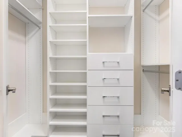 a view of walk in closet with empty racks