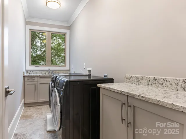 a utility room with a sink a window and a wooden floor