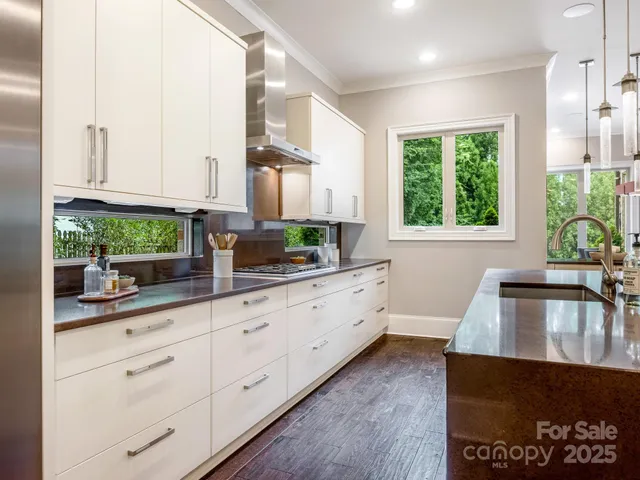 a kitchen with granite countertop white cabinets and a large window