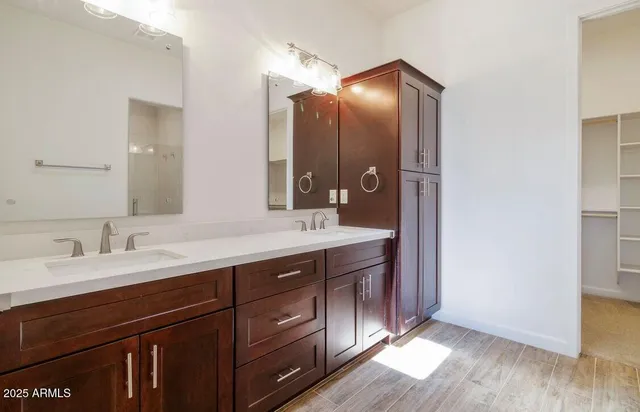 a view of an empty room with wooden floor and a bathroom