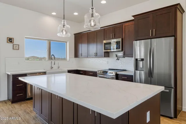 a kitchen with a refrigerator a sink a stove a microwave and island