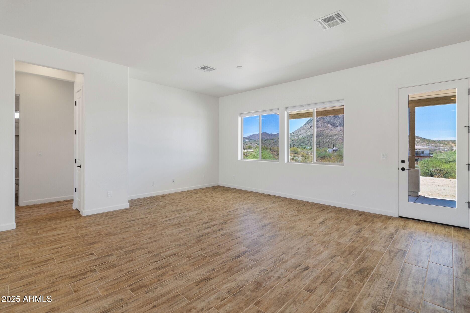 48126 North Coyote Pass Road New River, AZ 85087 - Photo 6 of 23 a view of an empty room with wooden floor and a window