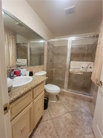 a bathroom with a granite countertop sink toilet a mirror and shower
