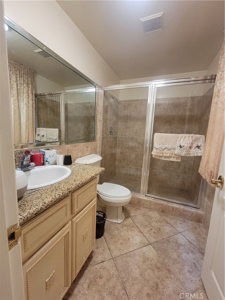8009 Rose Street Paramount, CA 90723 - Photo 14 of 18 a bathroom with a granite countertop sink toilet a mirror and shower