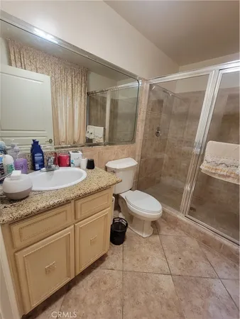a bathroom with a granite countertop sink toilet a mirror and shower