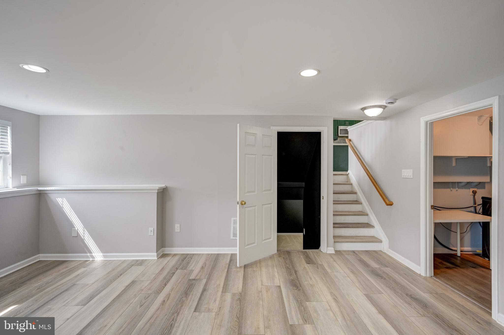 6495 Wesley Lane Elkridge, MD 21075 - Photo 31 of 37 a view of an empty room with wooden floor and stairs