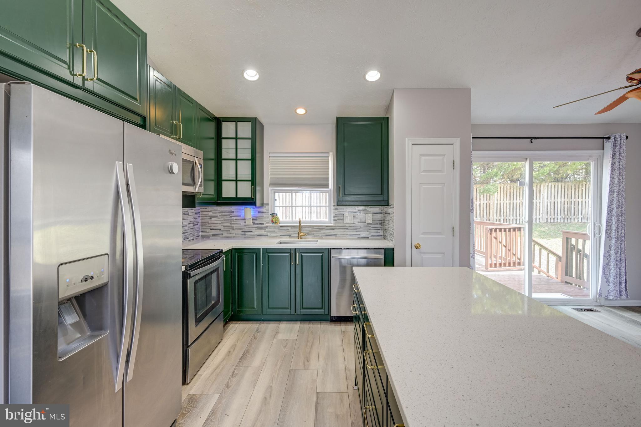 6495 Wesley Lane Elkridge, MD 21075 - Photo 7 of 37 a kitchen with stainless steel appliances granite countertop a refrigerator sink and cabinets