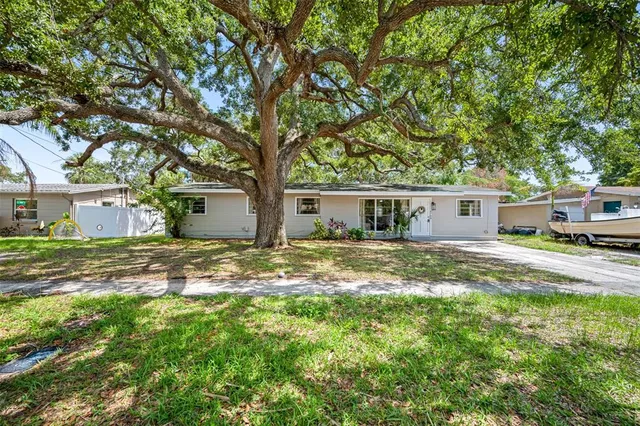 a front view of house with yard and trees around