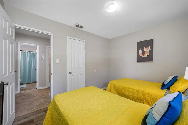 a bedroom with a bed and wooden floor