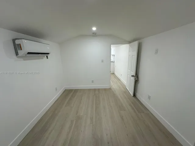a view of a room with wooden floor and white walls