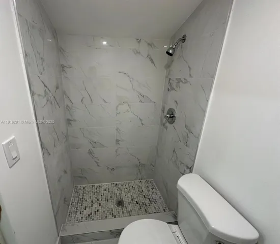 a bathroom with a toilet and a shower