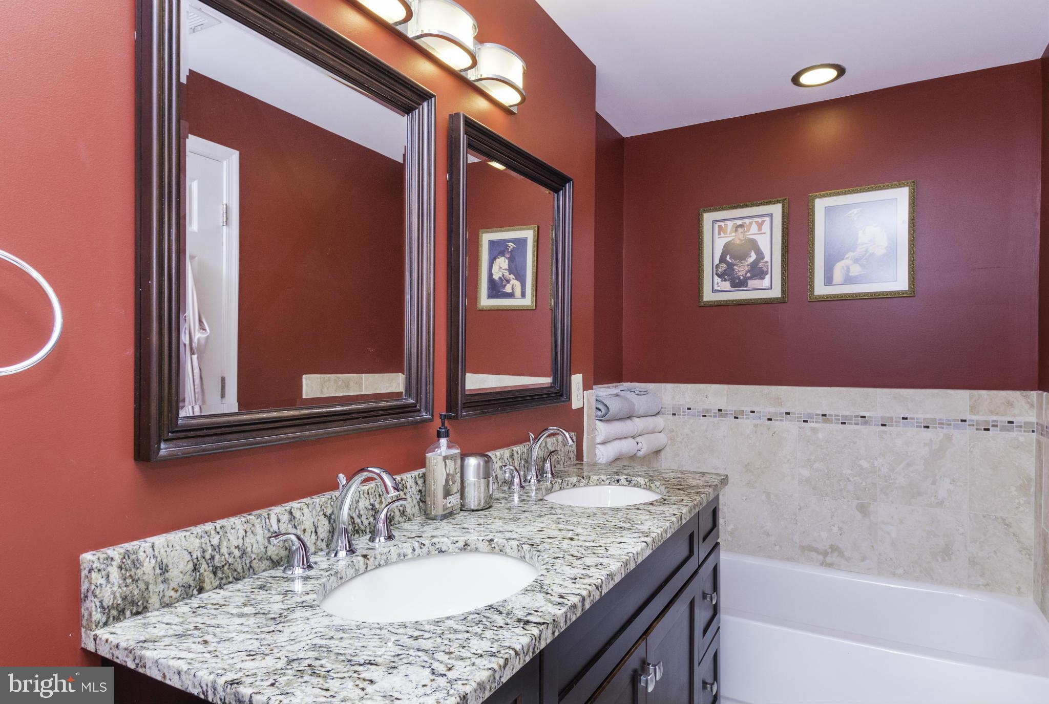 6600 Pine Road Alexandria, VA 22312 - Photo 15 of 28 a bathroom with a granite countertop sink a mirror and a bathtub