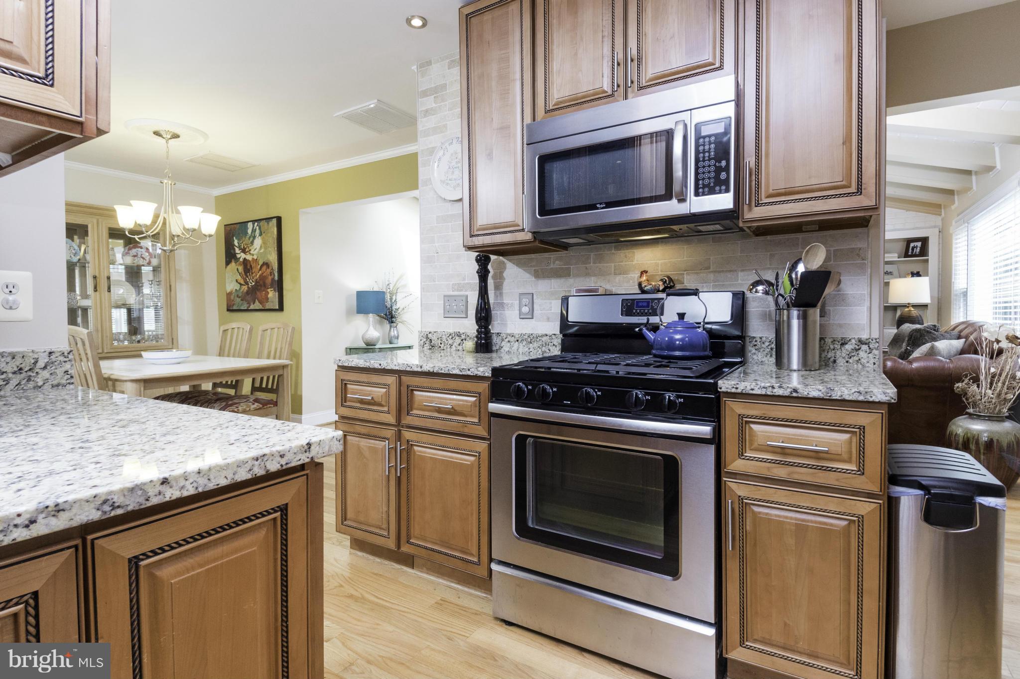 6600 Pine Road Alexandria, VA 22312 - Photo 10 of 28 a kitchen with stainless steel appliances granite countertop a stove microwave and cabinets