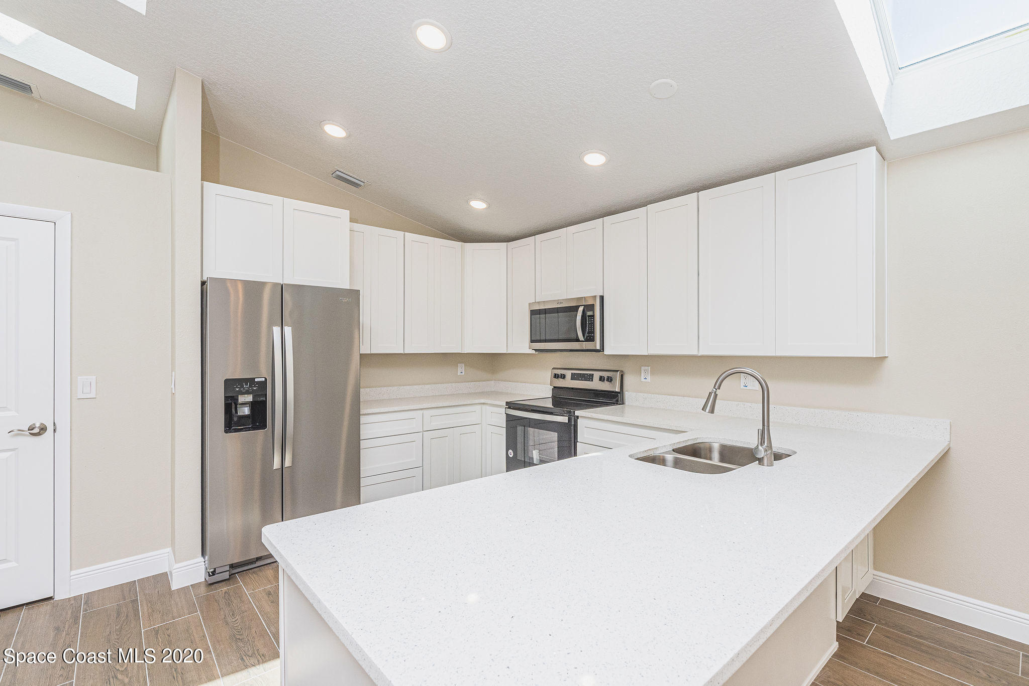336 Myrtlewood Road Melbourne, FL 32940 - Photo 22 of 72 a kitchen with stainless steel appliances a refrigerator sink microwave and cabinets