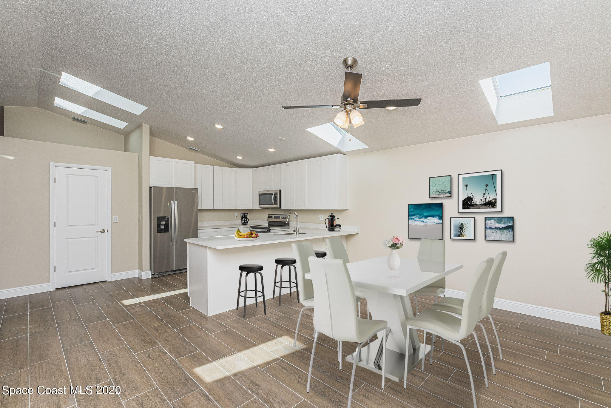 336 Myrtlewood Road Melbourne, FL 32940 - Photo 26 of 72 a kitchen with a dining table chairs stainless steel appliances and cabinets