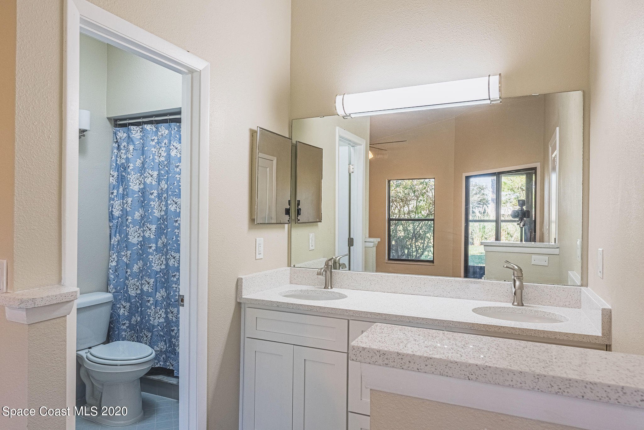 336 Myrtlewood Road Melbourne, FL 32940 - Photo 39 of 72 a bathroom with a toilet a sink and a large mirror
