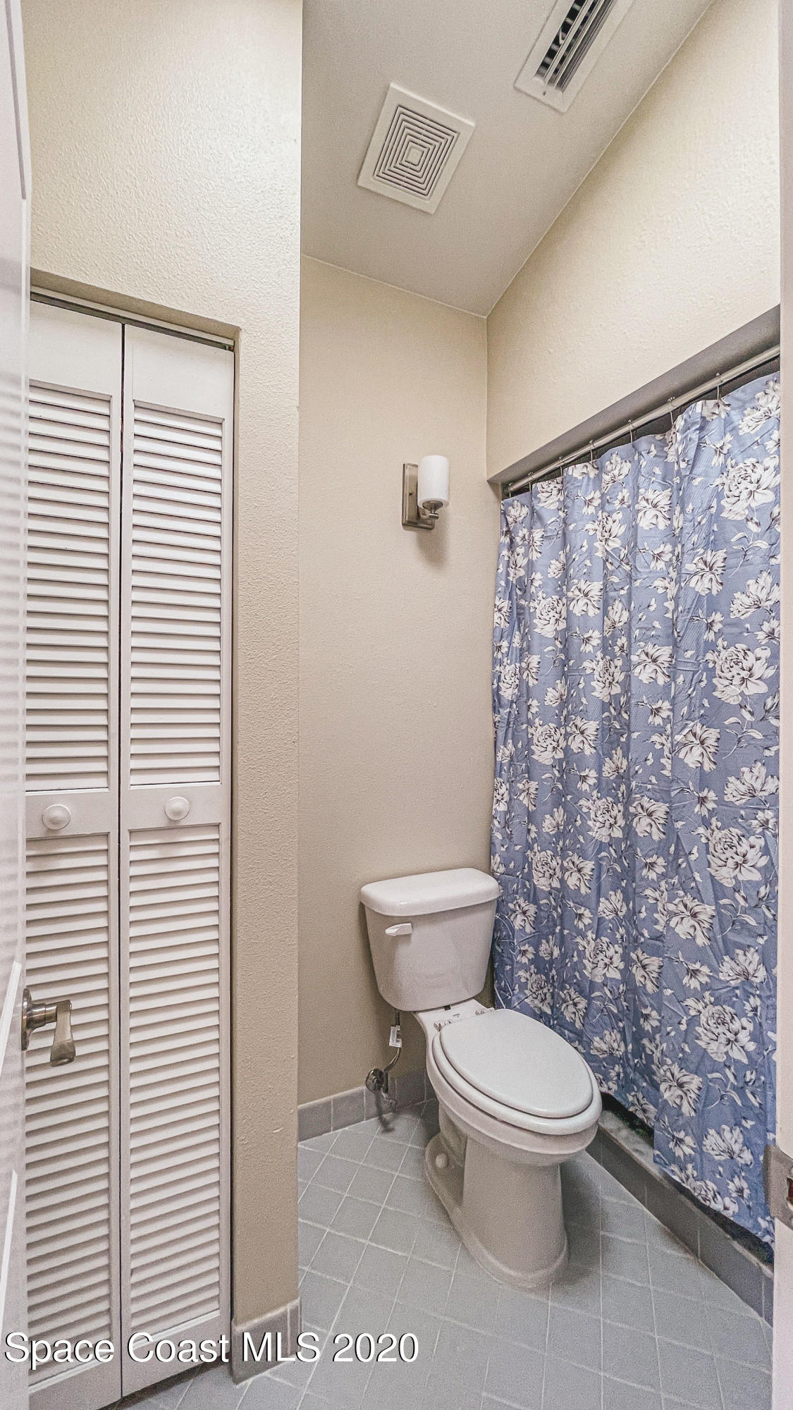 336 Myrtlewood Road Melbourne, FL 32940 - Photo 40 of 72 a white toilet sitting next to a shower curtain