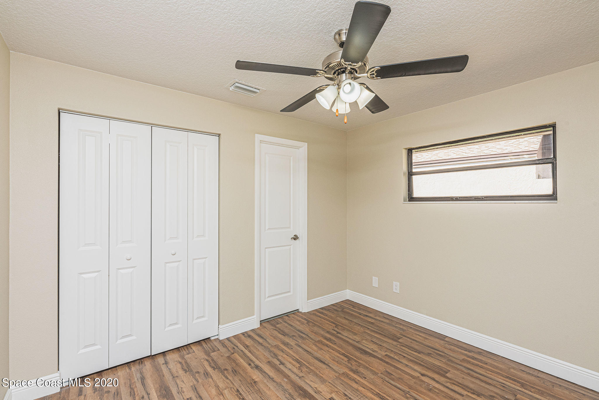 336 Myrtlewood Road Melbourne, FL 32940 - Photo 43 of 72 a view of an empty room with wooden floor