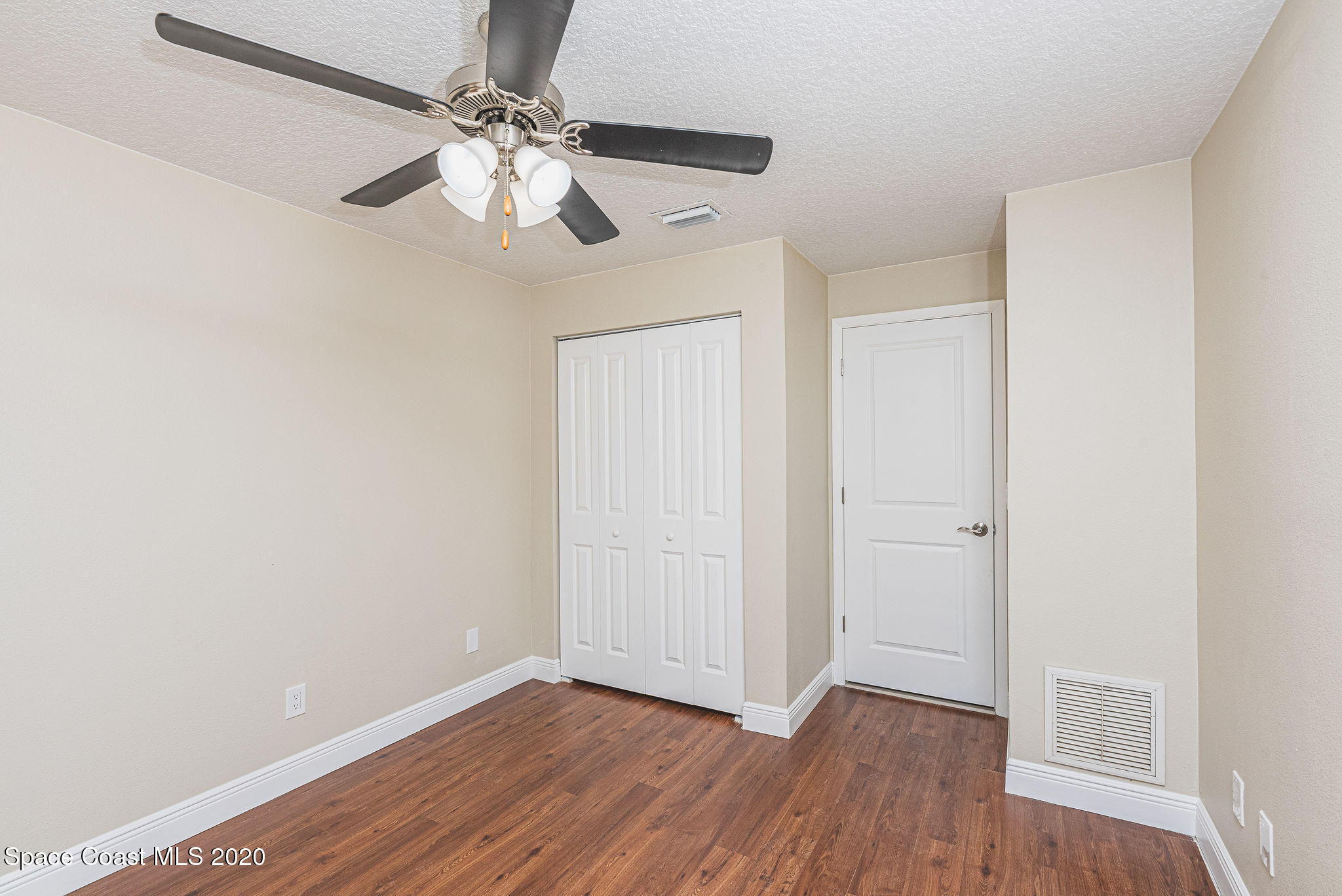 336 Myrtlewood Road Melbourne, FL 32940 - Photo 50 of 72 an empty room with wooden floor chandelier fan and closet area