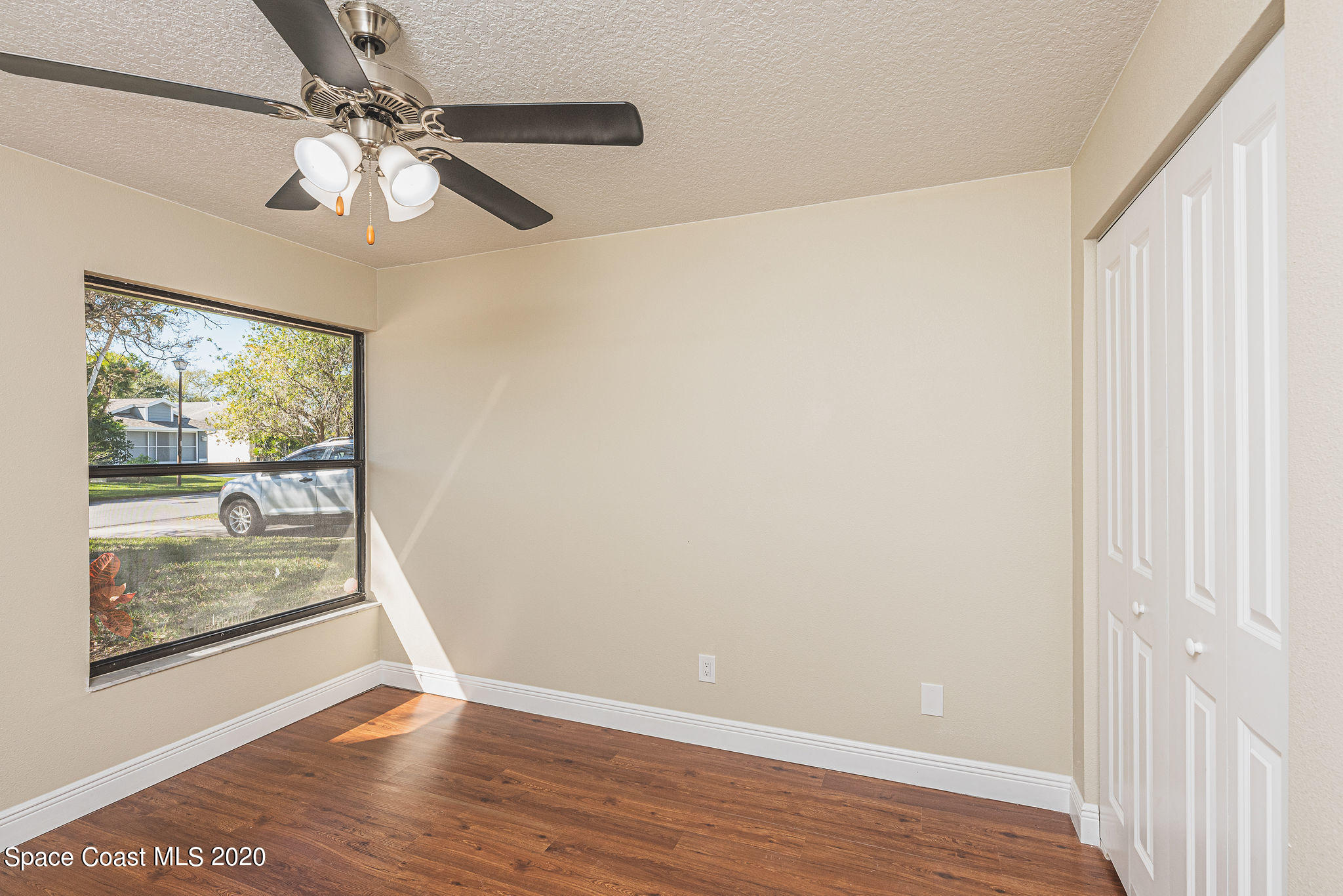 336 Myrtlewood Road Melbourne, FL 32940 - Photo 51 of 72 a view of an empty room with wooden floor and a window