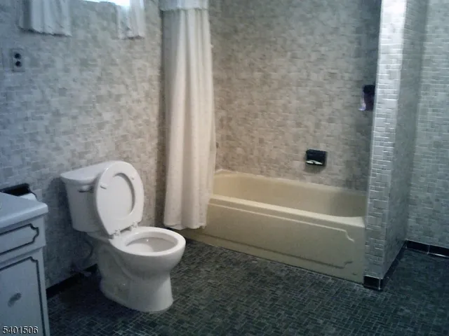 a white toilet sitting next to a bath tub