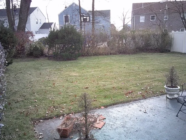a view of a backyard with plants and brick wall