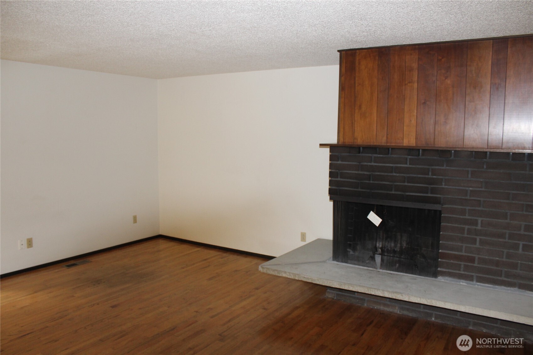 419 156th Place Northeast Bellevue, WA 98008 - Photo 6 of 22 a view of an empty room with wooden floor and a fireplace