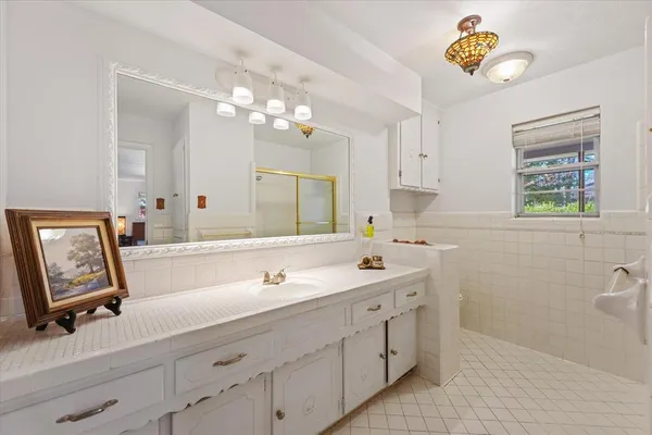 a bathroom with a sink a large mirror and a window