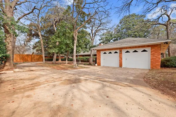 a front view of a house with a space and trees