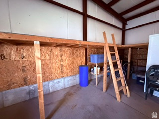 588 North 4500 West West Point, UT 84015 - Photo 45 of 61 Interior space featuring a concrete floor, built-in wooden mezzanine storage, exposed metal beams, and insulated panel walls