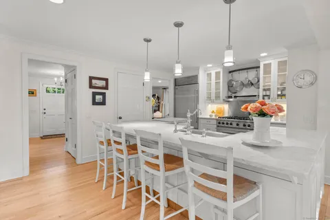 a view of a dining room and livingroom with furniture wooden floor a chandelier