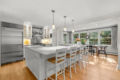 a view of a dining room and livingroom with furniture wooden floor a chandelier