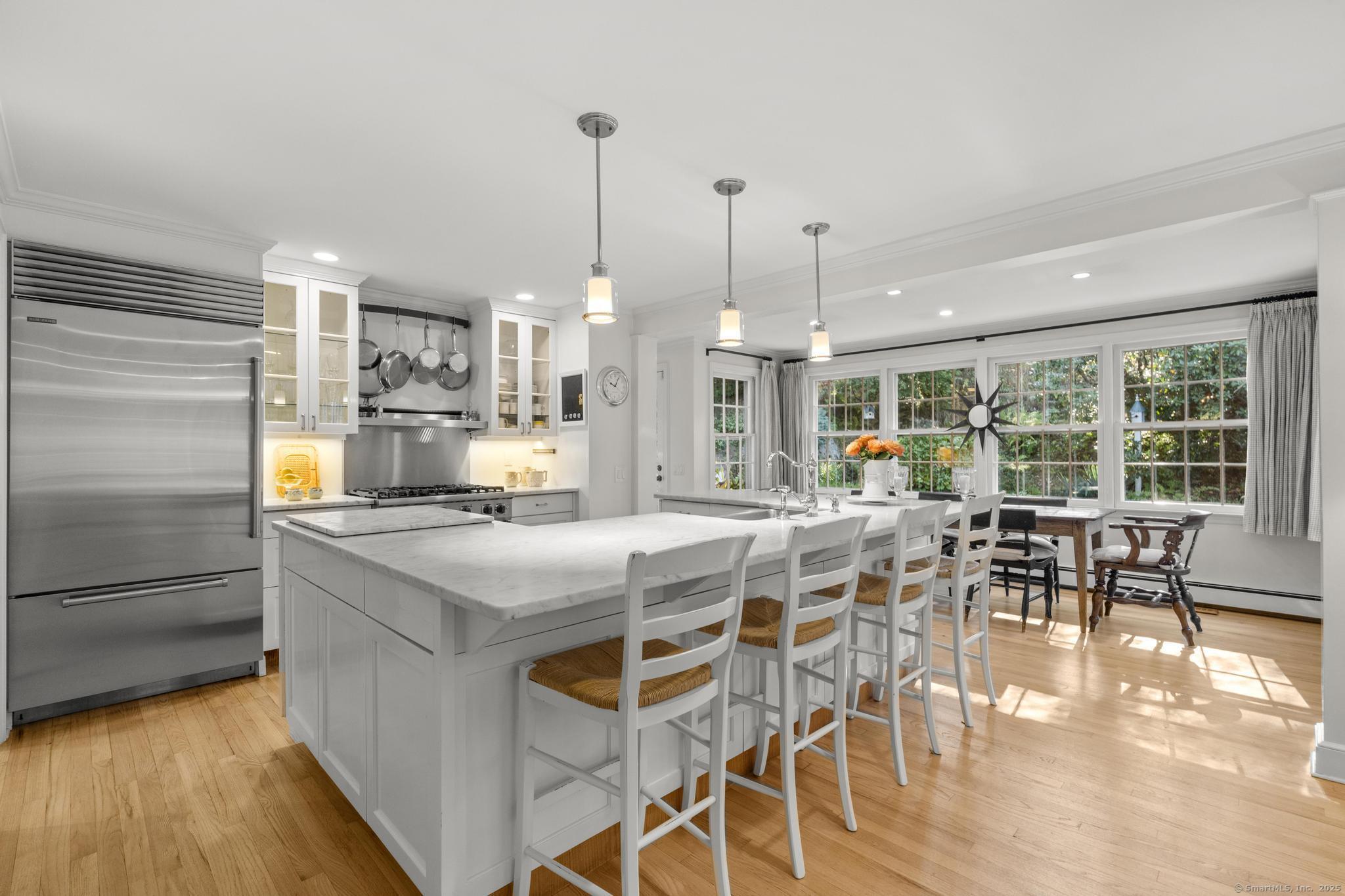 1165 Stillson Road Fairfield, CT 06824 - Photo 16 of 40 a view of a dining room and livingroom with furniture wooden floor a chandelier