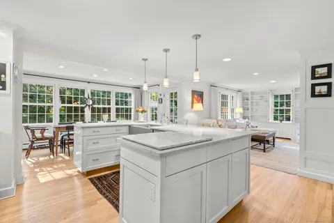 a kitchen with kitchen island granite countertop a stove and a wooden floors