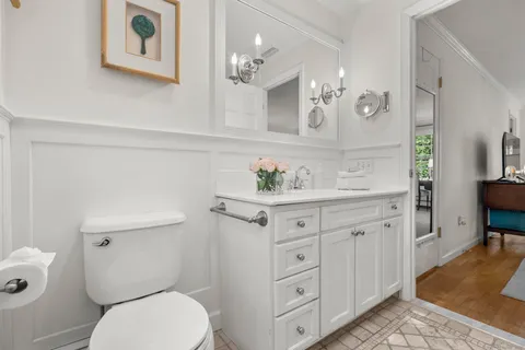 a bathroom with a granite countertop toilet sink and mirror