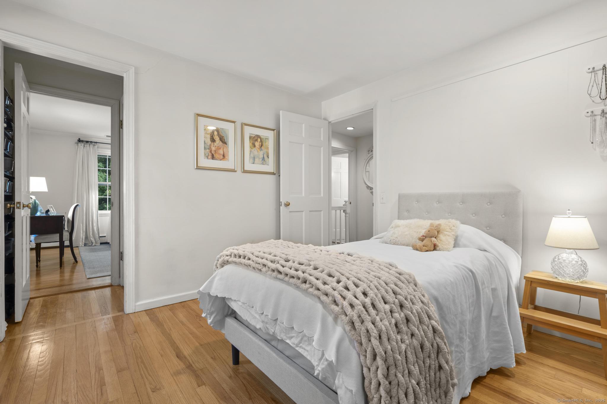 1165 Stillson Road Fairfield, CT 06824 - Photo 28 of 40 a bedroom with a bed and wooden floor