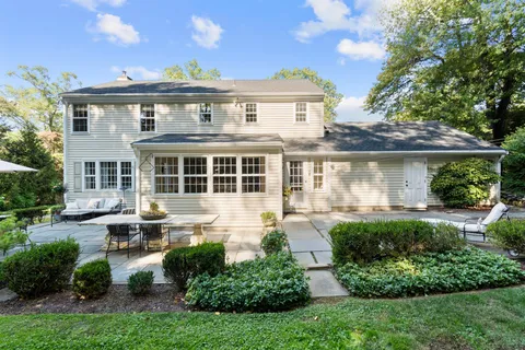 a front view of a house with a yard and outdoor seating