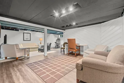 a view of a patio with table and chairs under an umbrella with large trees